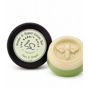 Alpha-gal safe solid lotion bar in tin with bee stamp on marble surface by Rabbit Hole Products